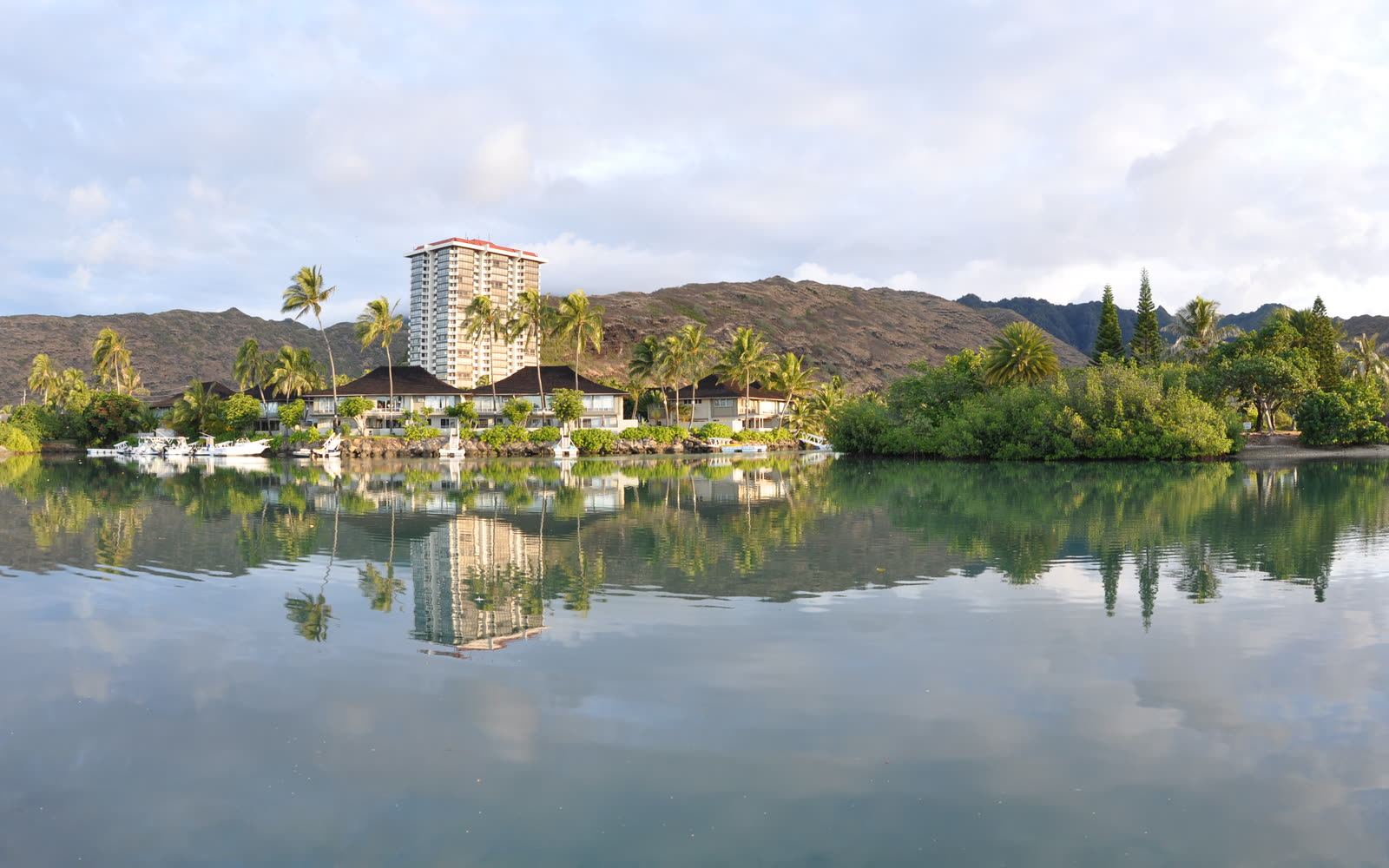 Marina-front homes reflected in calm Hawaiʻi Kai water beneath the hillside