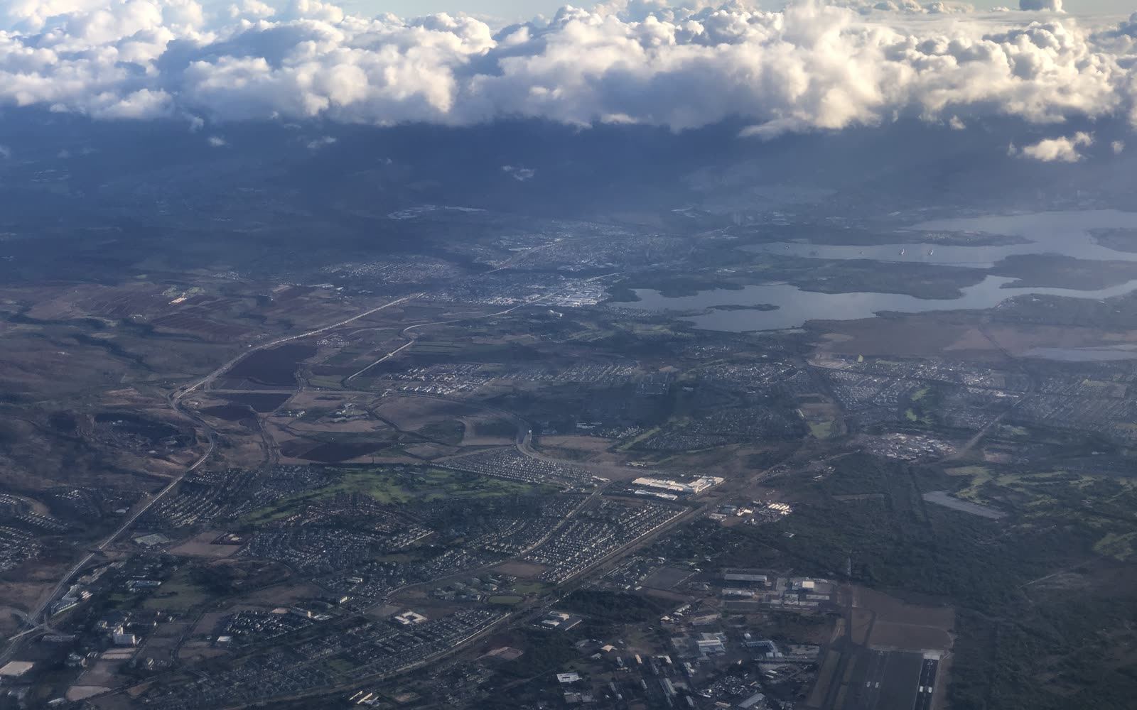 Aerial view across Waipahu neighborhoods toward Pearl Harbor and the Koʻolau range