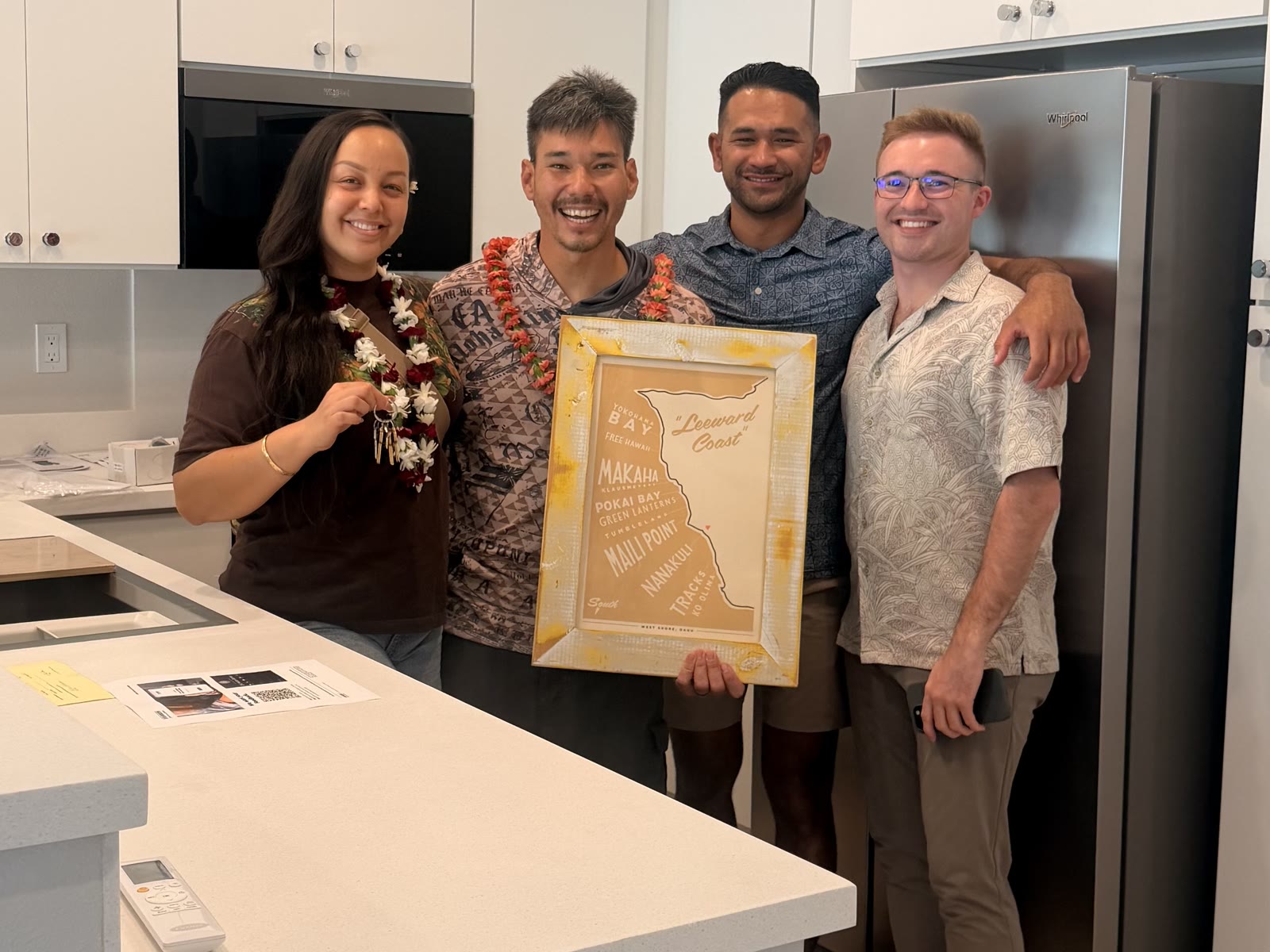 New homeowners and their real estate team celebrating with keys in the kitchen