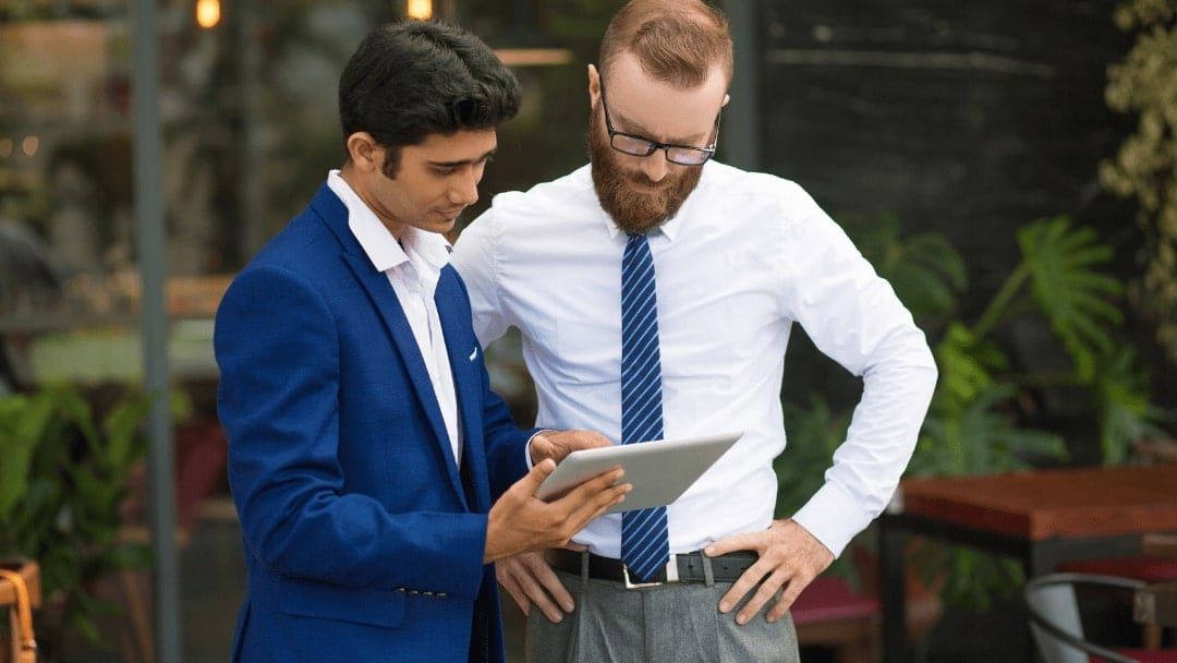 Two people reviewing figures together on a tablet